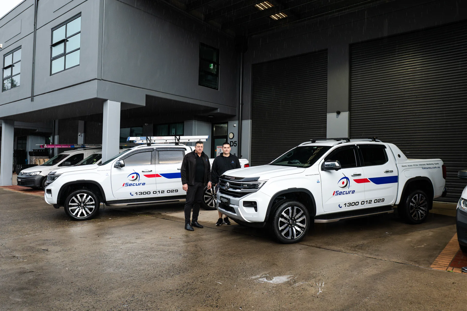 The iSecure owners standing with their utes at the Kingsgrove headquarters