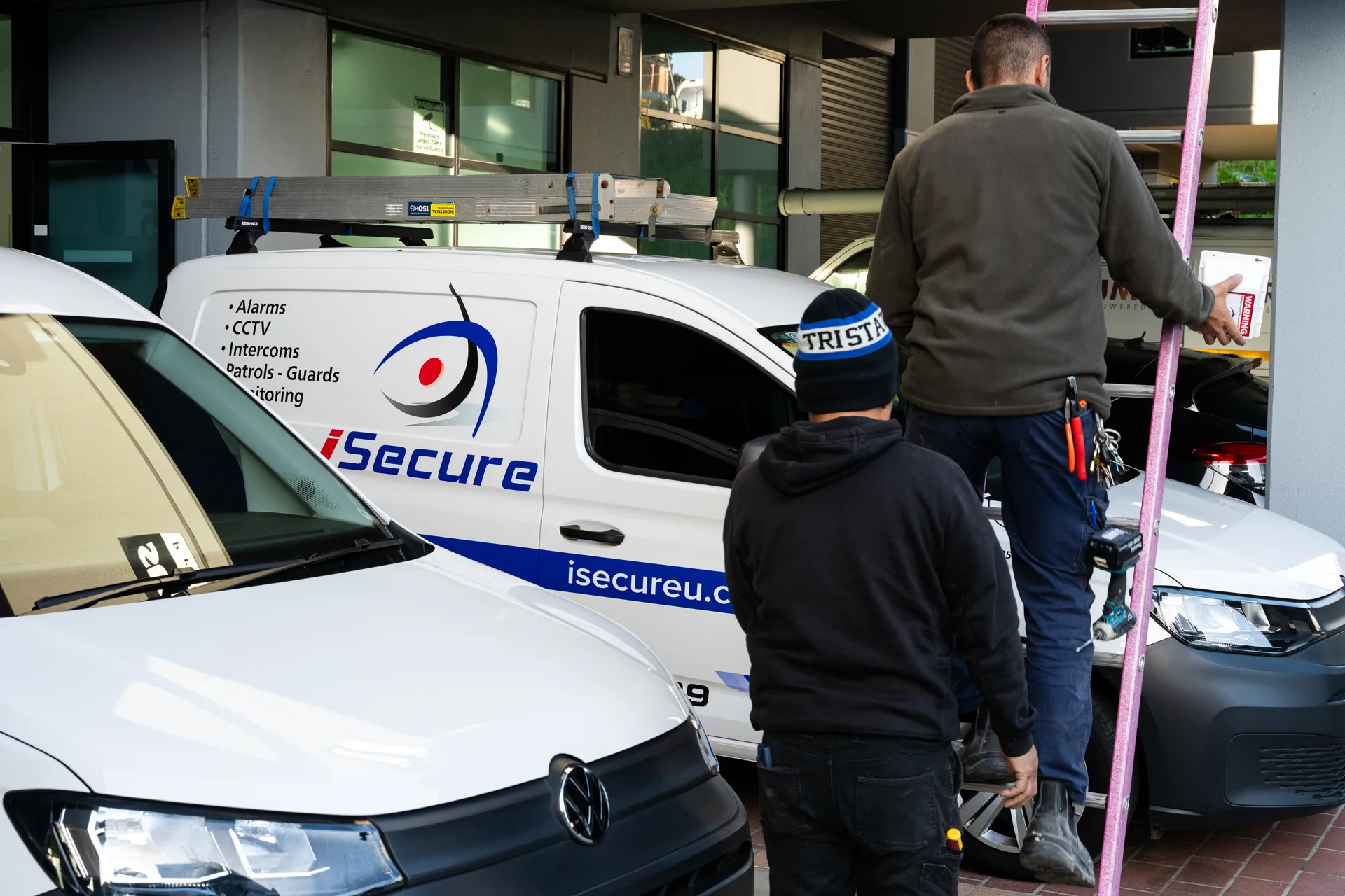 iSecure technicians loading ladders at their vans on a Sydney street