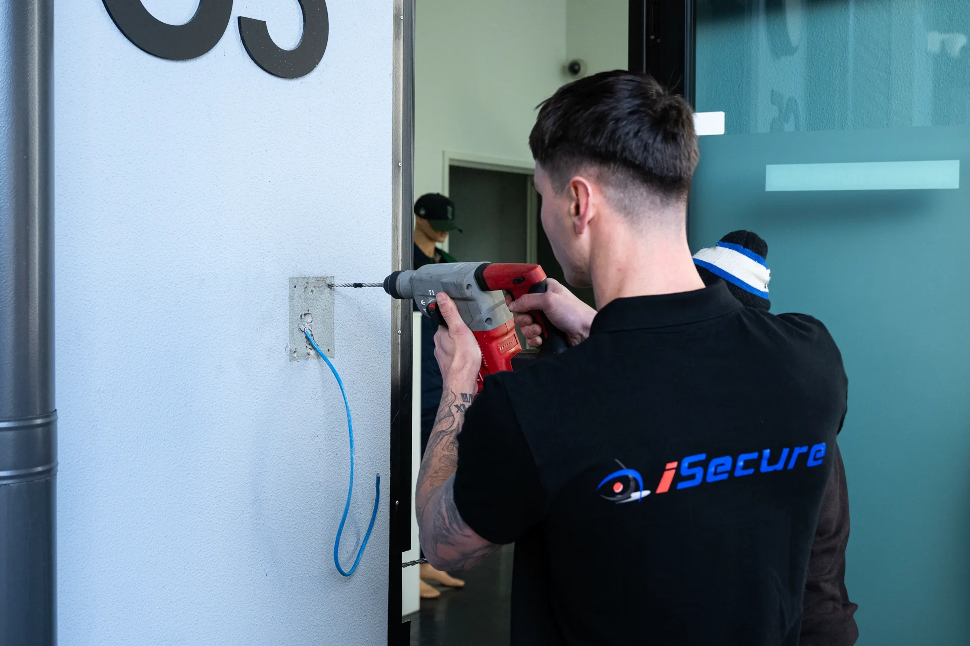 An iSecure technician drilling to fit door hardware
