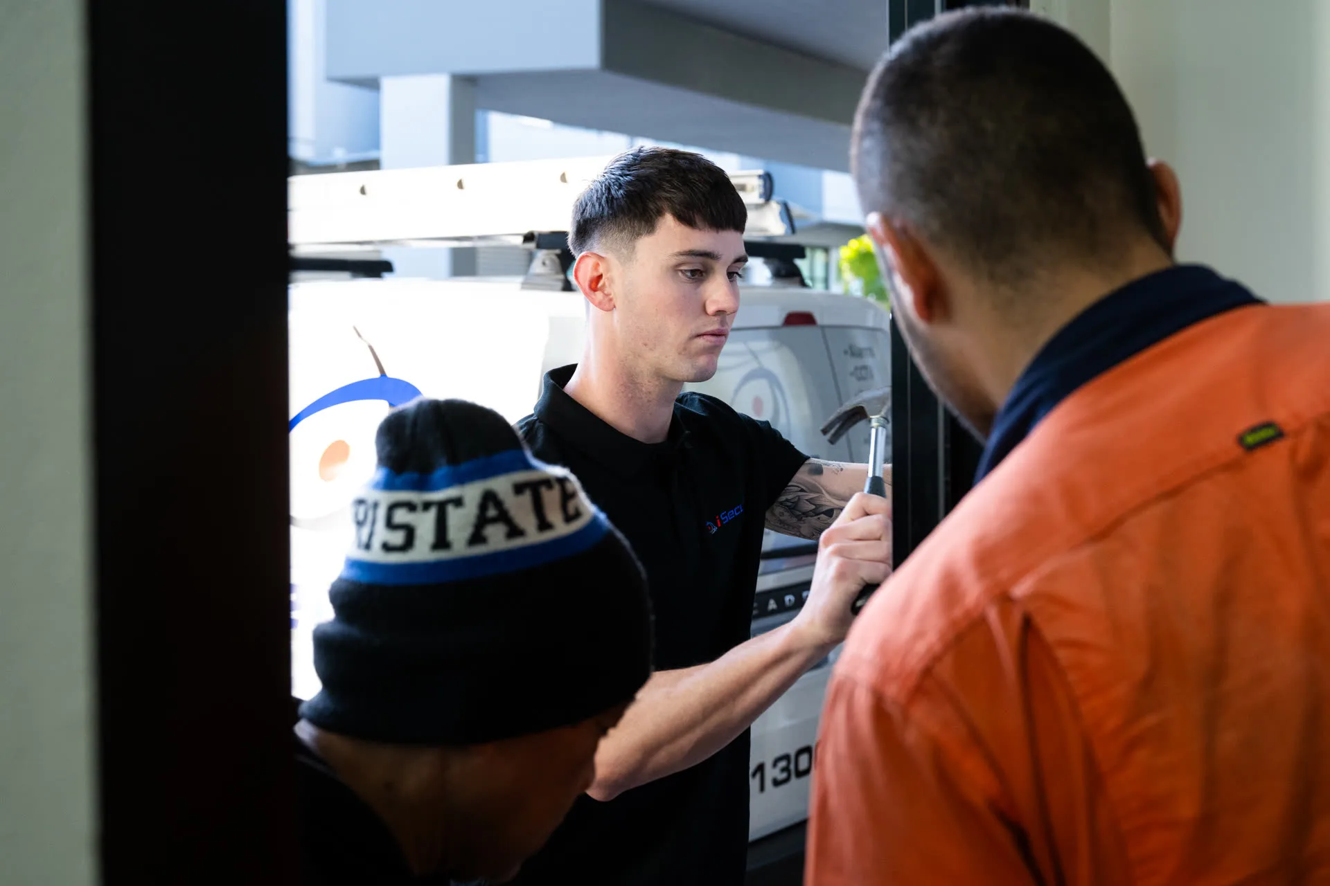 iSecure technicians fitting security hardware to a doorway