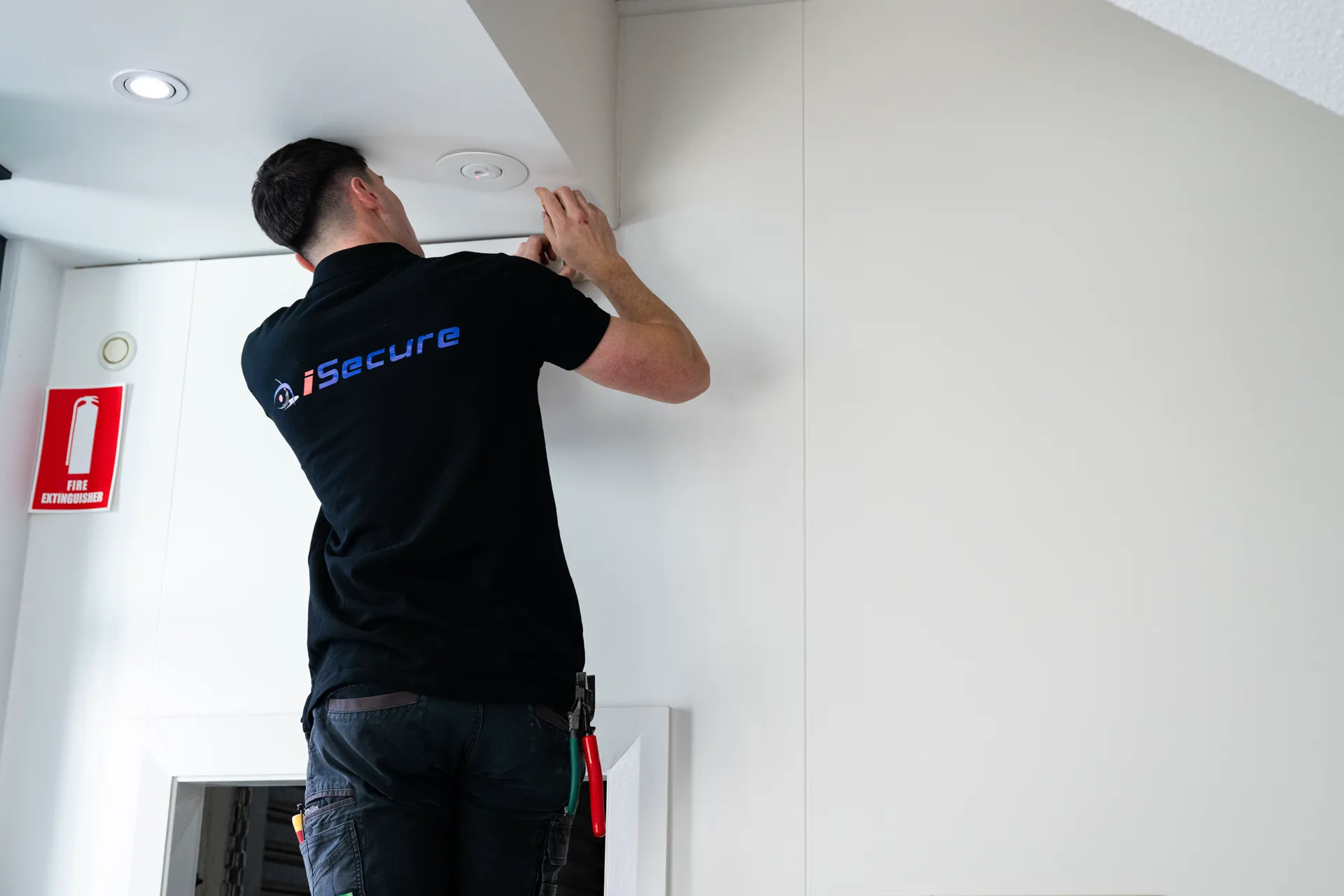 An iSecure technician installing a ceiling sensor