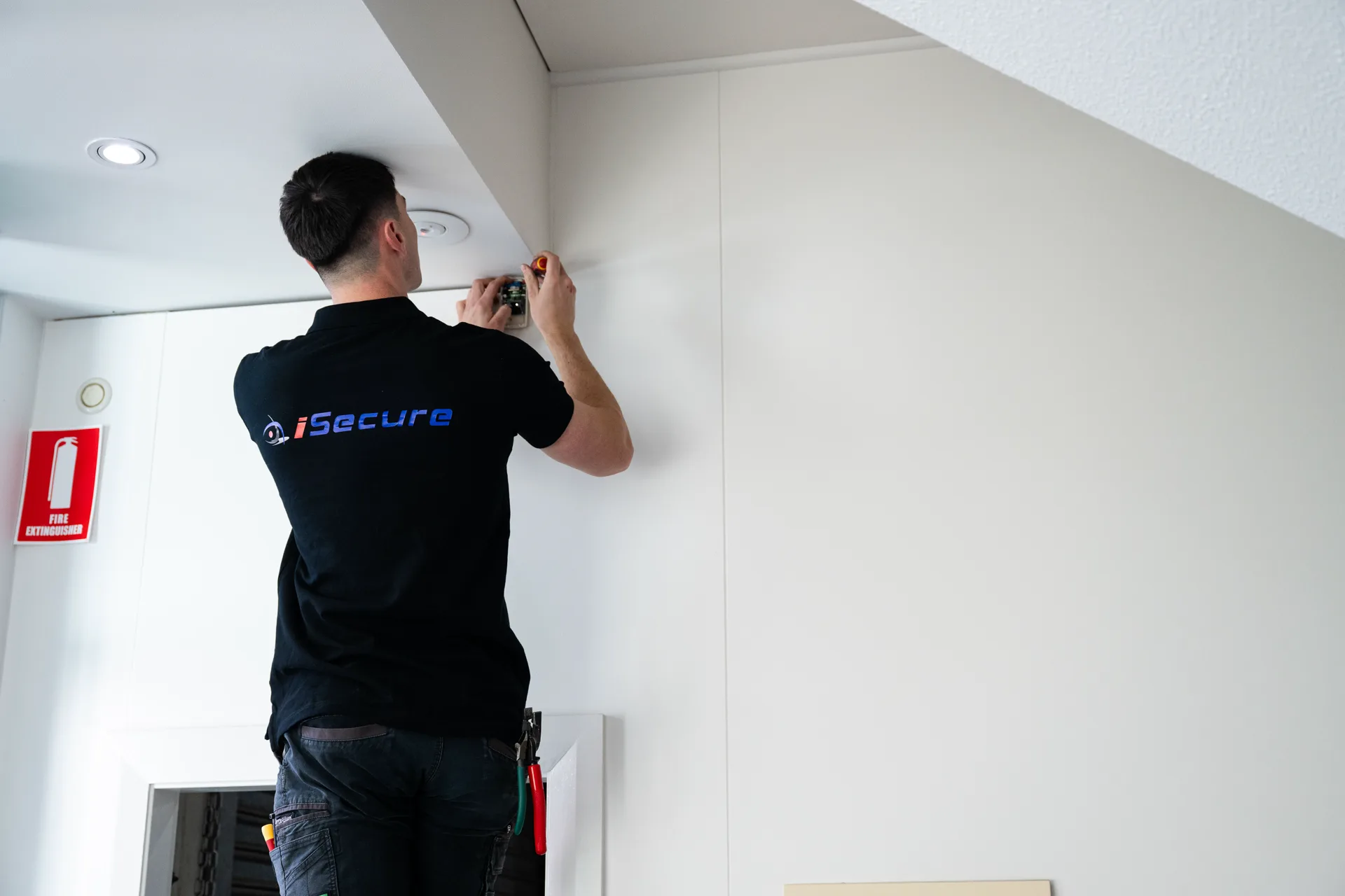 An iSecure technician fitting an access device above a doorway