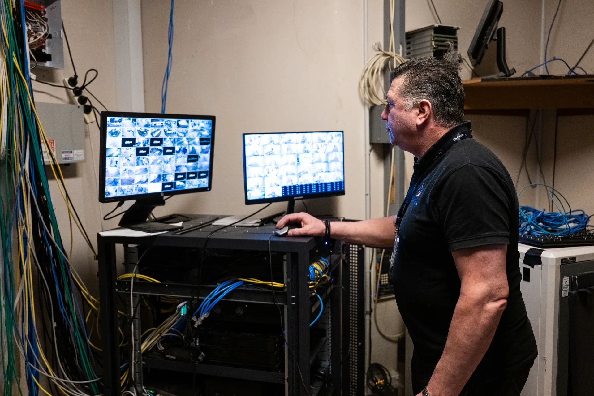 An iSecure technician checking camera feeds at a comms rack