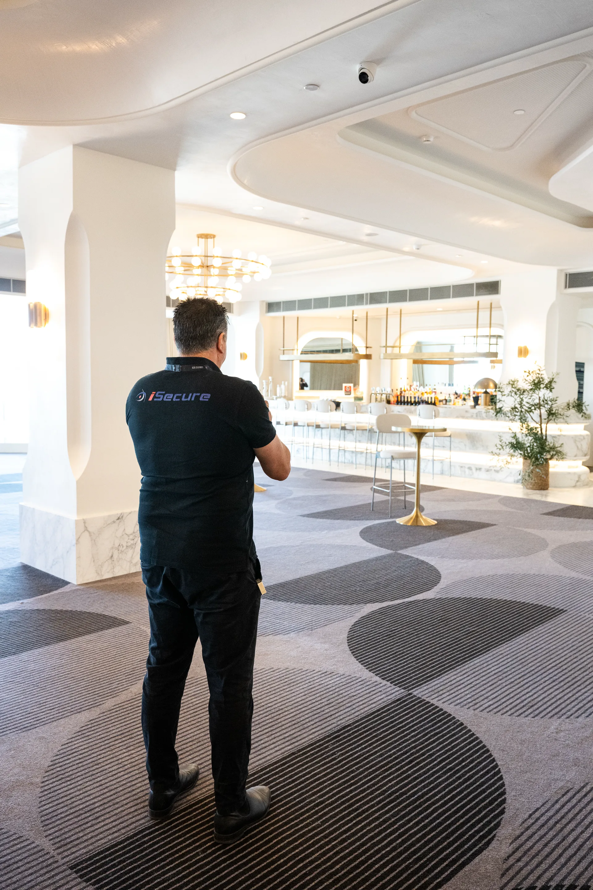 An iSecure technician checking dome camera coverage in a function room