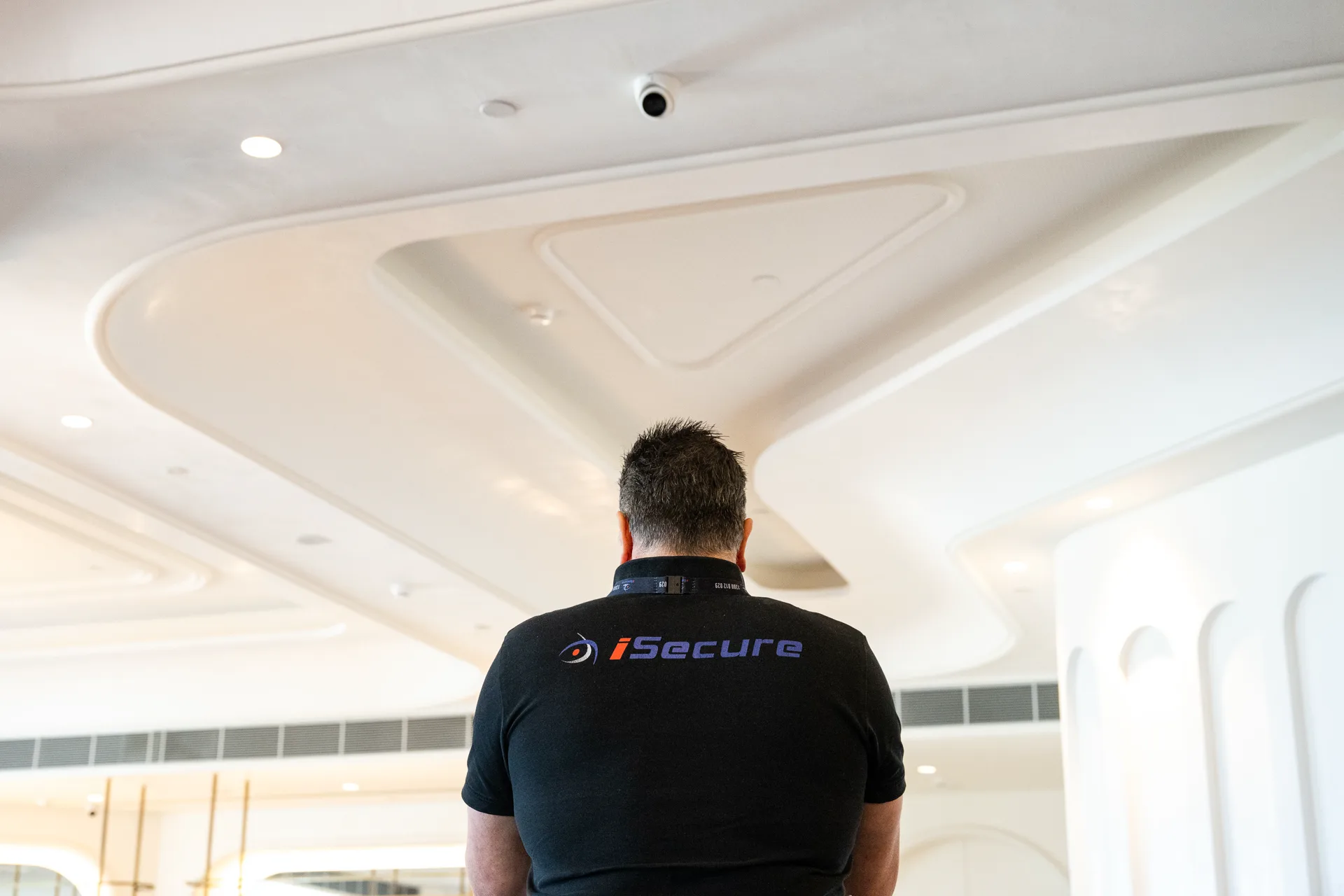 An iSecure technician checking a ceiling camera in a function room