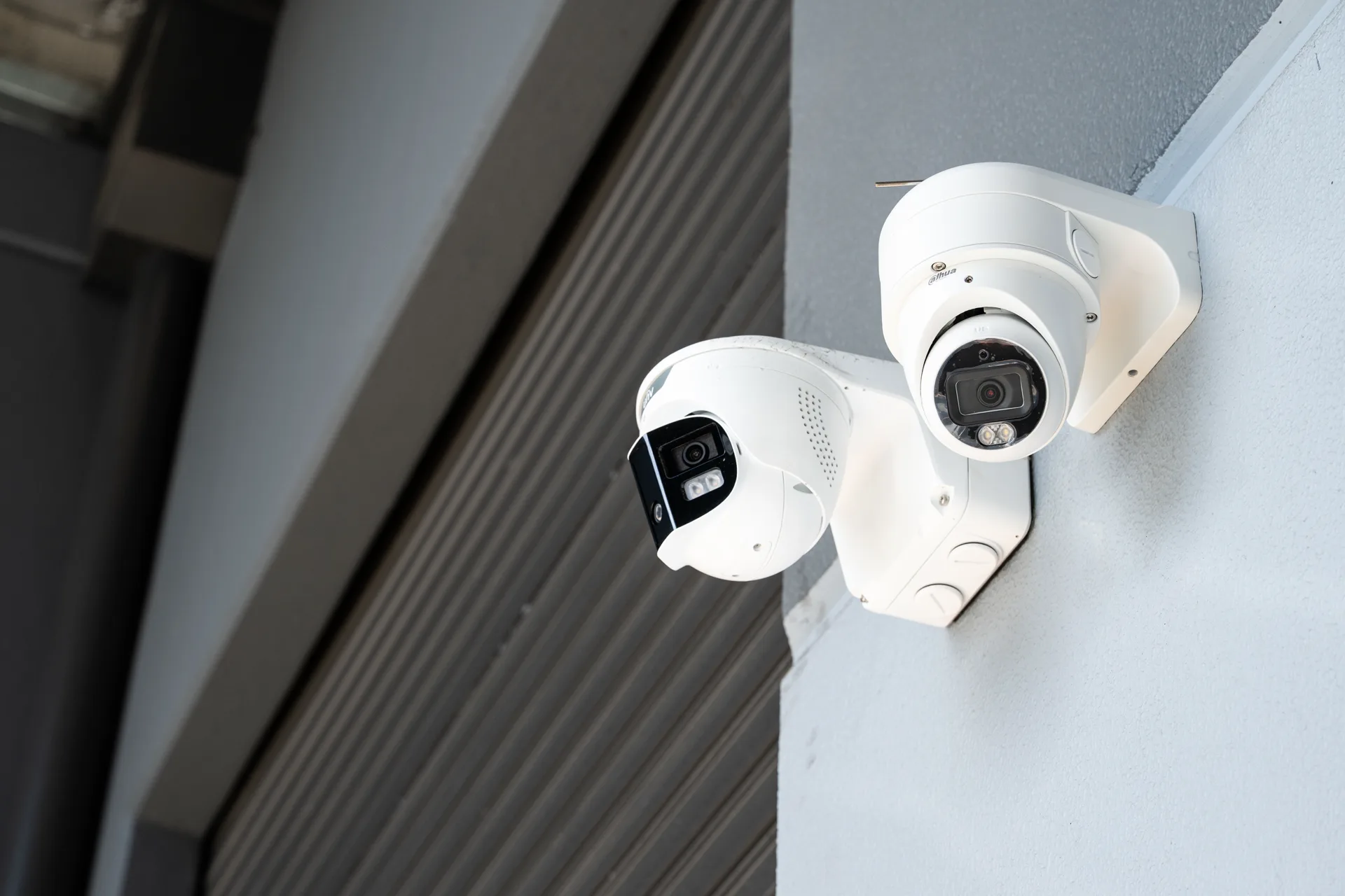 Entry cameras covering a building corner above a roller door