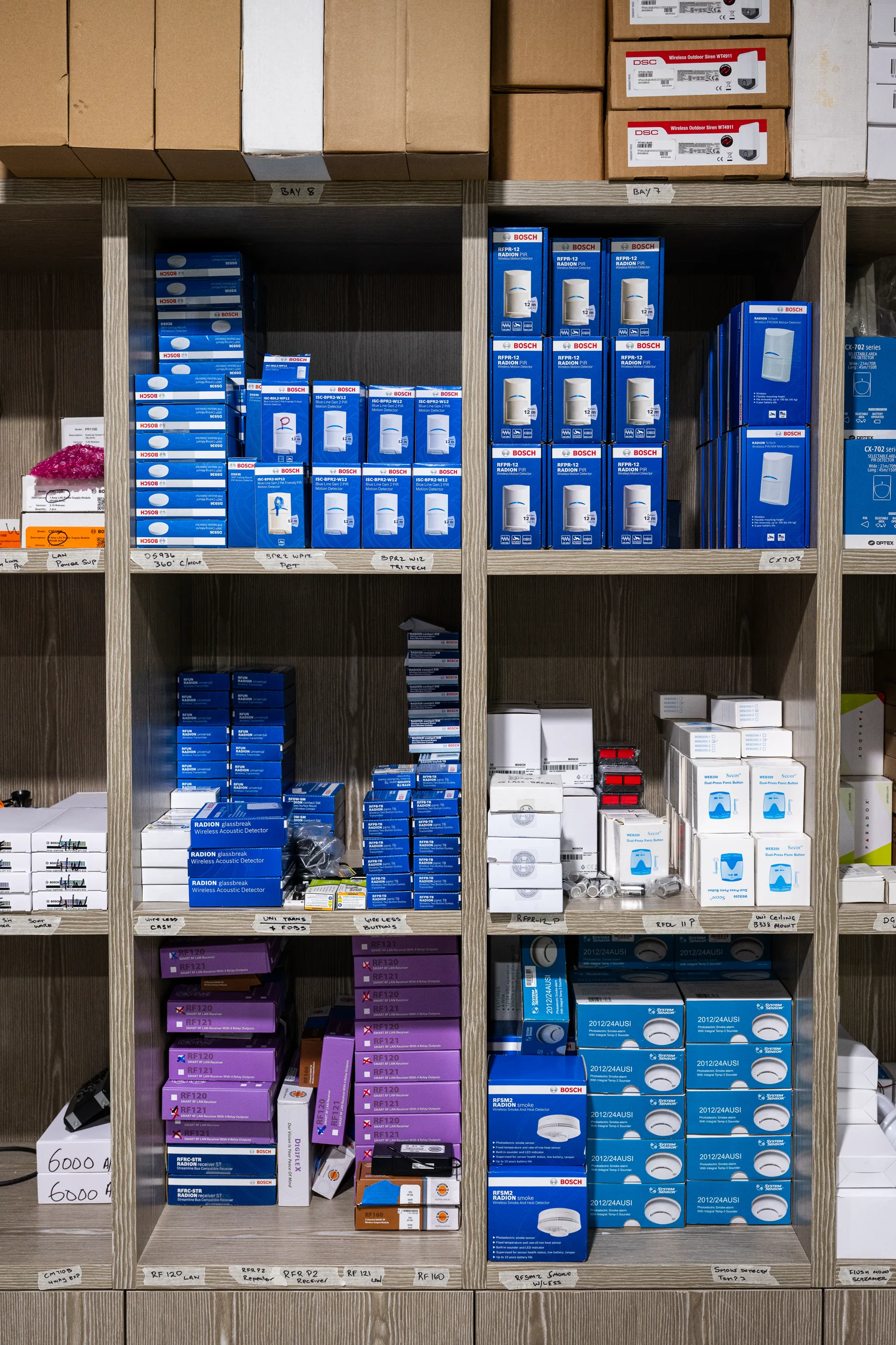 Shelves of alarm sensors and detectors in the iSecure warehouse